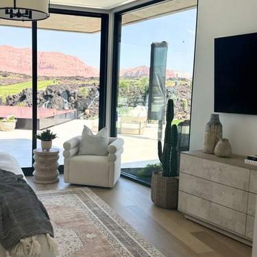 Modern living room with a view of mountains through large windows.